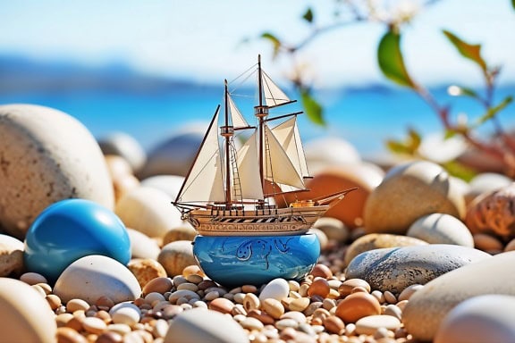 Handgefertigtes Miniatur-Spielzeugmodell eines Segelschiffes auf einem Stein