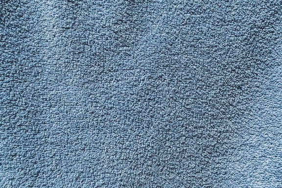 Zbliżenie tekstury ciemnoniebieskiego ręcznika bawełnianego ze szczegółową strukturą włókien