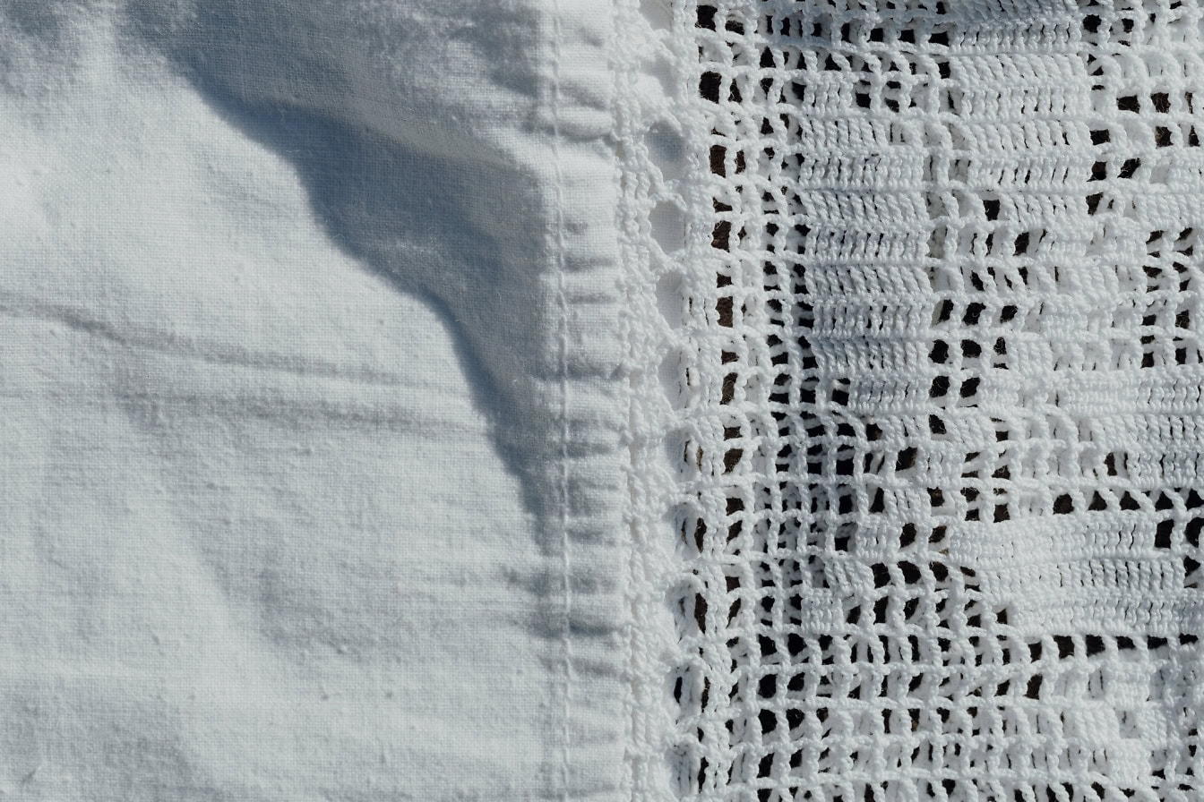 Texture of white cotton fabric with hand-woven lace