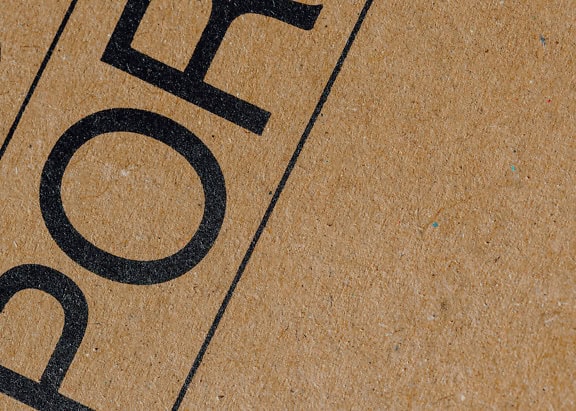 La trama delle lettere nere su una scatola di cartone marrone realizzata con cellulosa riciclata