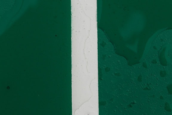 Vertical white line on the middle of a wet dark green surface