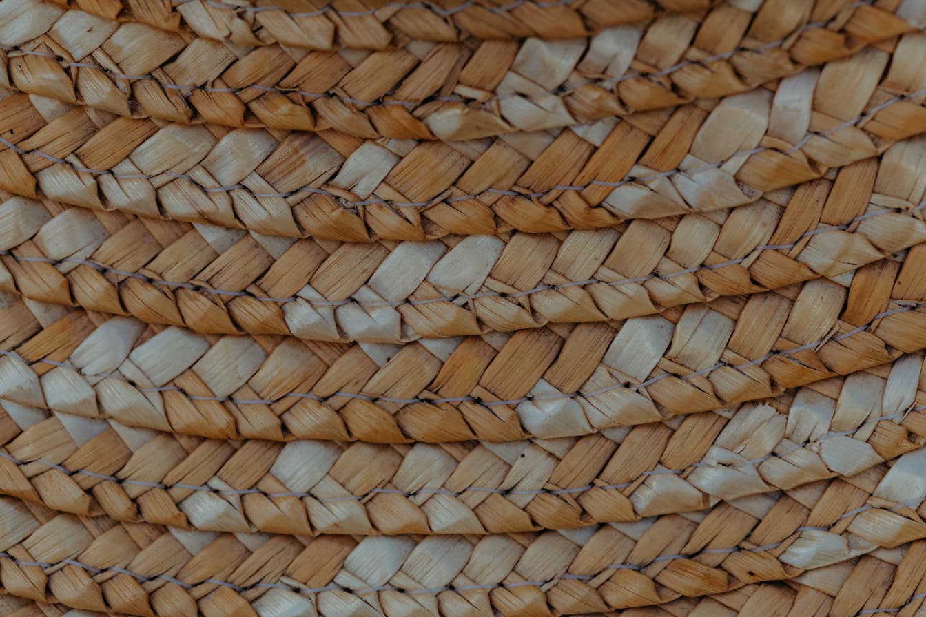 Texture of a handwoven rattan basket with a close-up of a yellowish brown surface