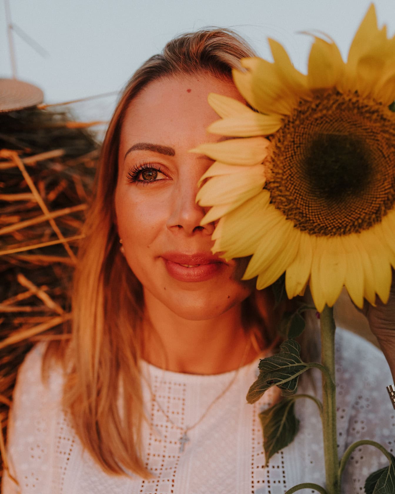 Potret seorang gadis cantik tersenyum dengan bunga matahari lebih dari setengah wajahnya