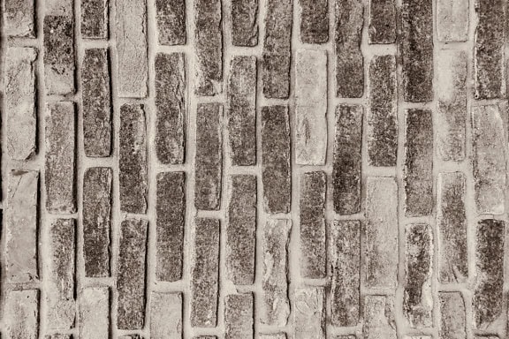 Sepiafoto av textur av en gammal tegelvägg med vertikalt staplade tegelstenar och tjock cement