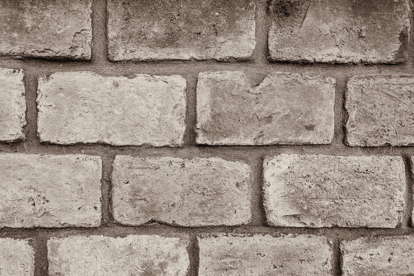 Textura sépia de uma parede de tijolos feita de tijolos pequenos velhos empilhados horizontalmente