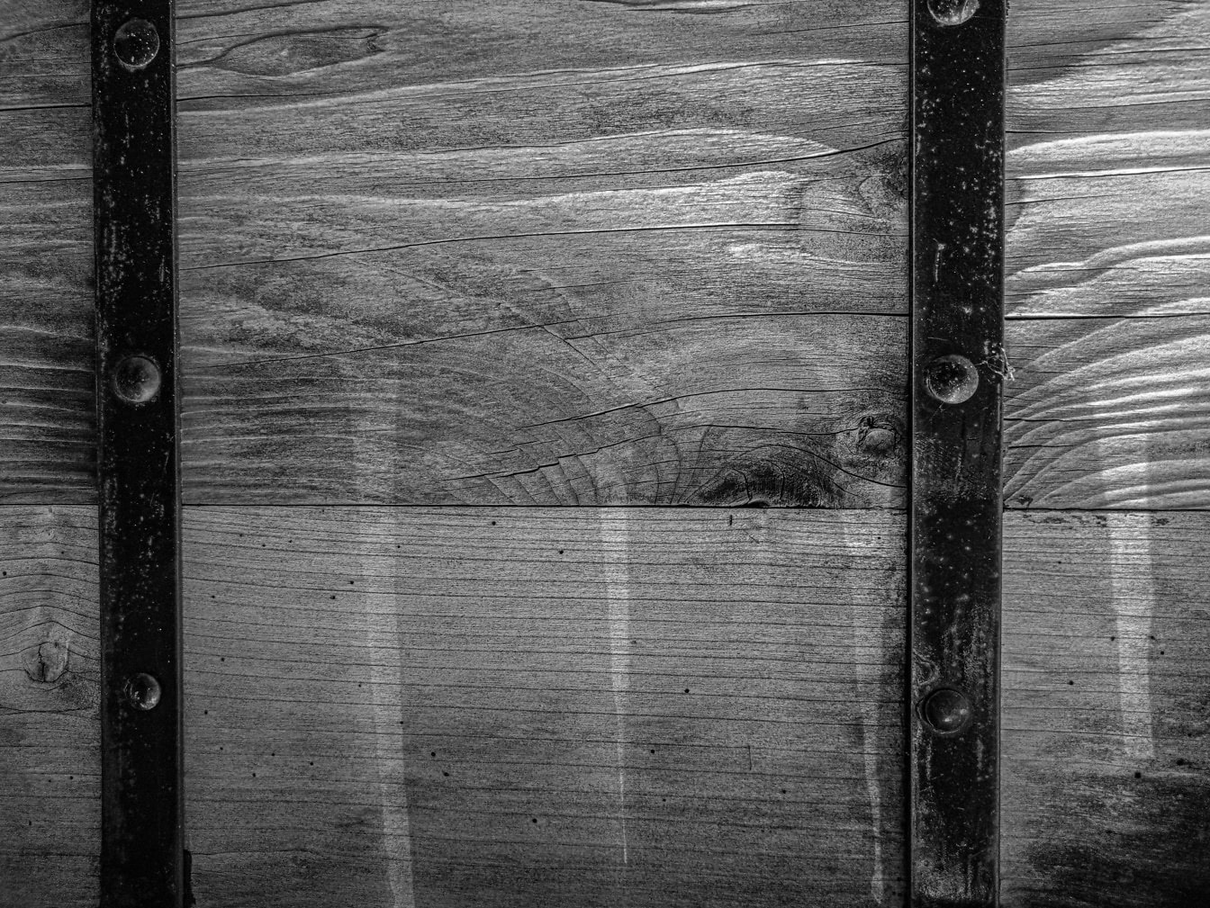 Photo en noir et blanc d’un cadre en fonte noire sur une surface en bois