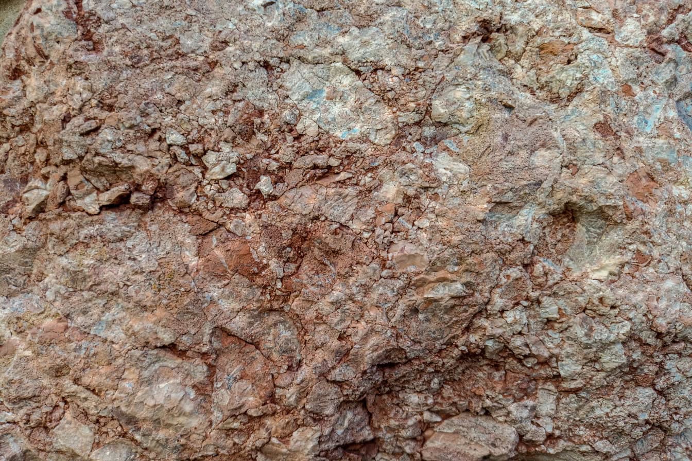 Κοντινή υφή ενός τραχιού κοκκινωπού-καφέ βράχου γρανίτη