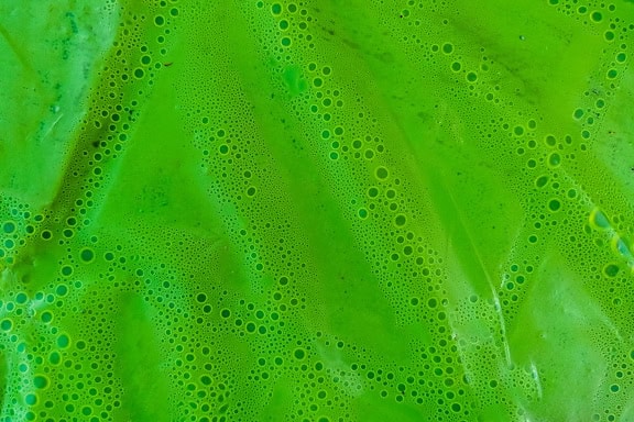 Tekstura nieprzezroczystej zielonkawej nylonowej folii z bąbelkami pod spodem