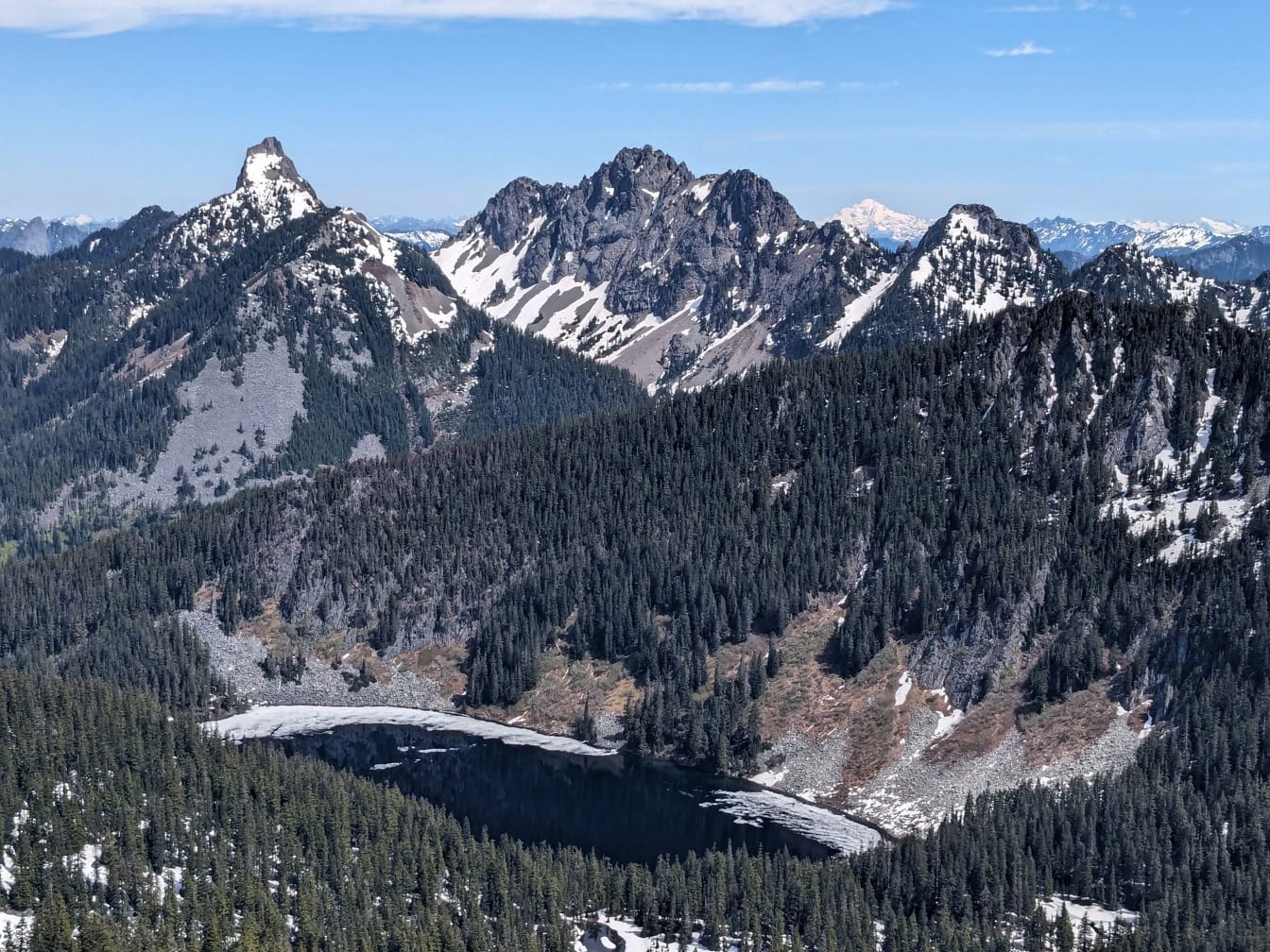 Gebirgskette mit schneebedeckten Bäumen und einem See am Granite Mountain in Washington