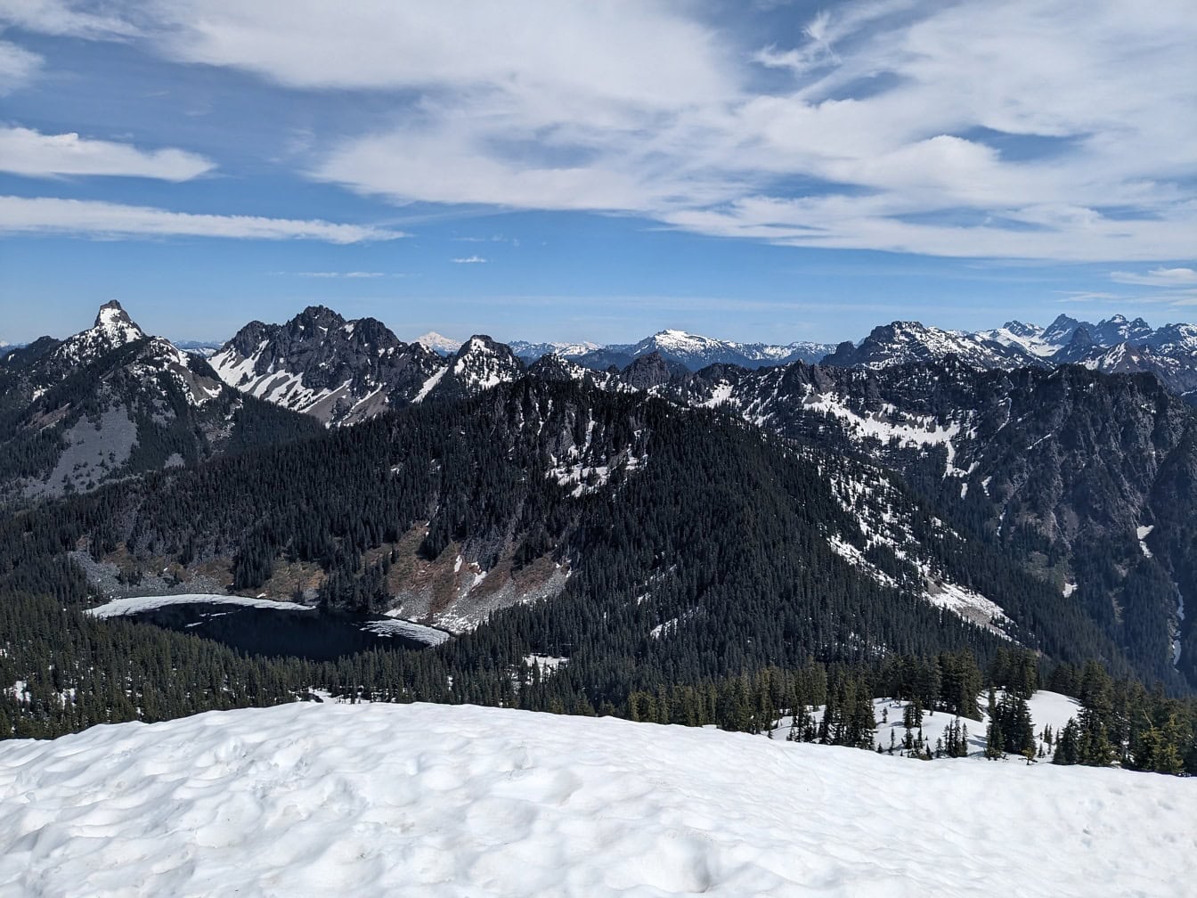 Изглед към Гранитната планина във Вашингтон със заснежени планински върхове и с дървета и езеро