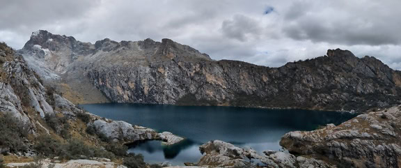 A nagy magasságú Charup-tó 4.450 méteren Huaraz városa közelében Peruban, sziklás hegyekkel a háttérben