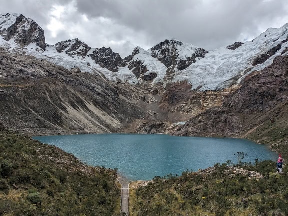 Rocotuyo-See in Raramaypampa in Peru, umgeben von Bergen mit Schnee auf der Spitze