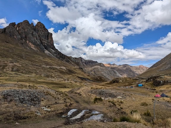 Fjellkjede med campingplass i en dal ved fjellkjeden Cordillera Huayhuash i Andesfjellene i Peru