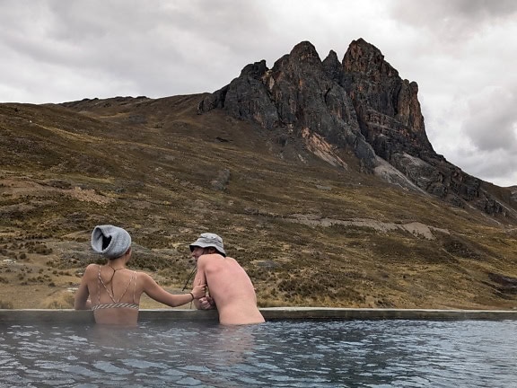 People enjoying in a pool at Guñoc hot springs at Viconga, a thermal waters on the Cordillera Huayhuash mountain range in Ancash in Peruvian Andes
