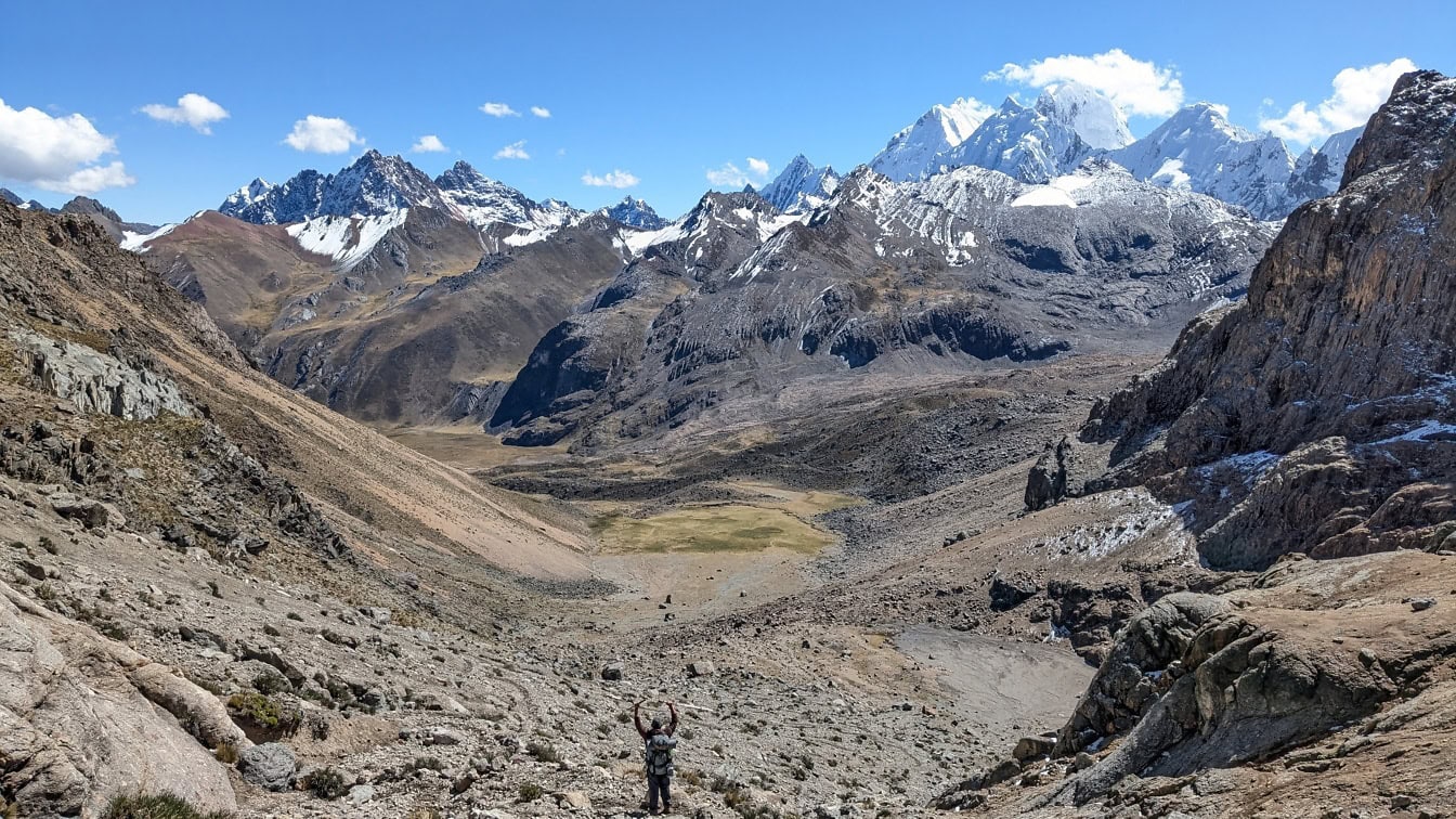 페루 안데스 산맥의 Cordillera Huayhuash 산맥에서 전경의 계곡에 서 있는 사람, 배경에 산이 있는 사람