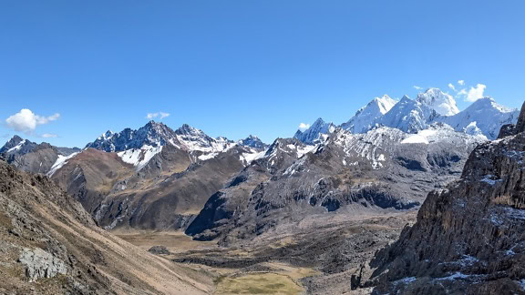 남미 페루 안데스 산맥의 Cordillera Huayhuash 산맥에 푸른 하늘이 있는 눈 덮인 산이 있는 계곡