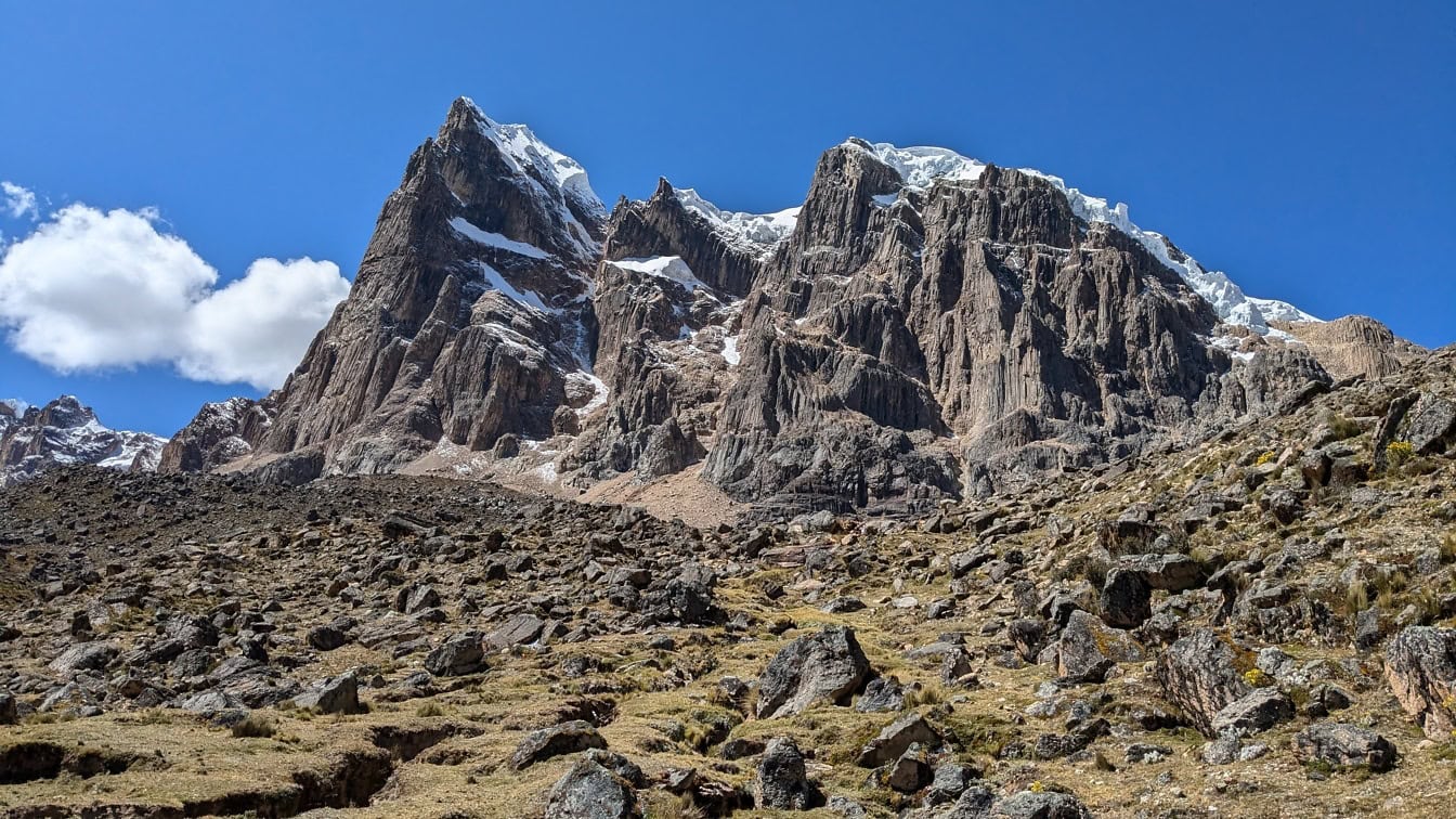 Vârfuri montane stâncoase cu zăpadă în vârf în parcul natural din lanțul muntos Cordillera Huayhuash din Anzi din Peru, în America de Sud