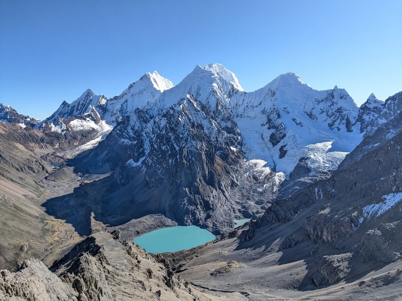 Bergskedja med snötäckta toppar och en sjö Palcacocha vid bergskedjan Cordillera Huayhuash i Anderna i Peru i Sydamerika