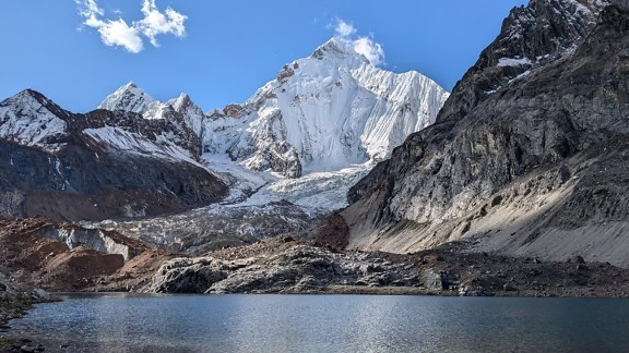 Величествена гледка към заснежените планински върхове на заден план с езеро на преден план