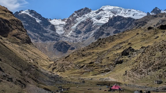 Campingplass med telt i en dal ved fjellkjeden Cordillera Huayhuash i Andesfjellene i Peru