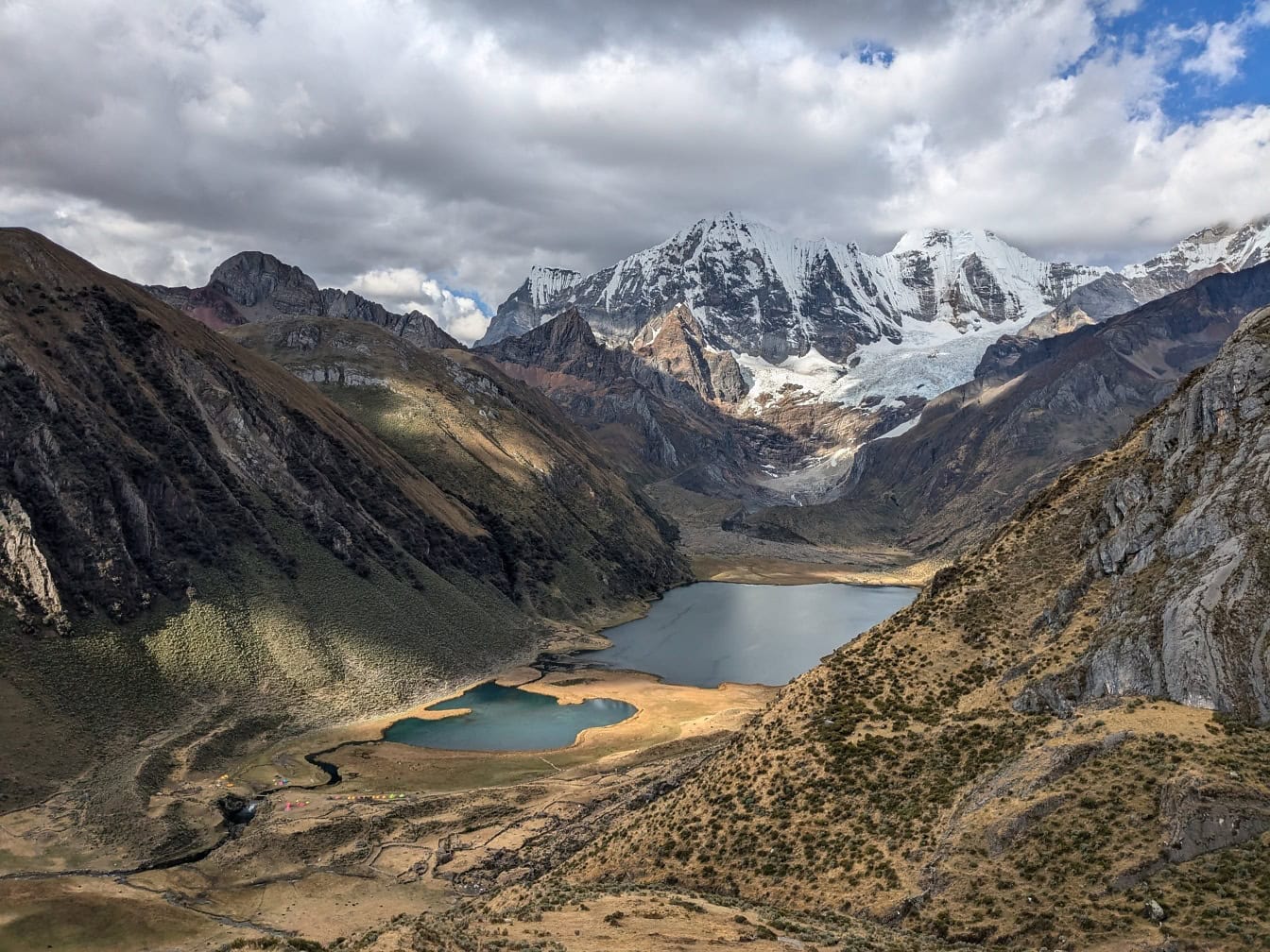 ทิวทัศน์มุมกว้างของทะเลสาบที่ล้อมรอบด้วยภูเขาที่ Cordillera Huahuash เทือกเขาในเทือกเขาแอนดีสของเปรู
