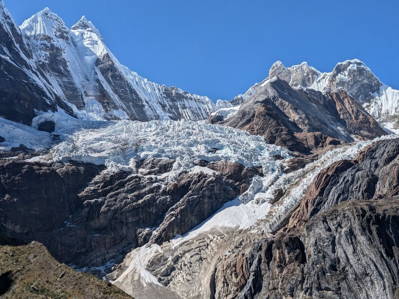 Snöigt berg med en glaciär vid bergskedjan Cordillera Huayhuash i Anderna i Peru i regionerna Ancash