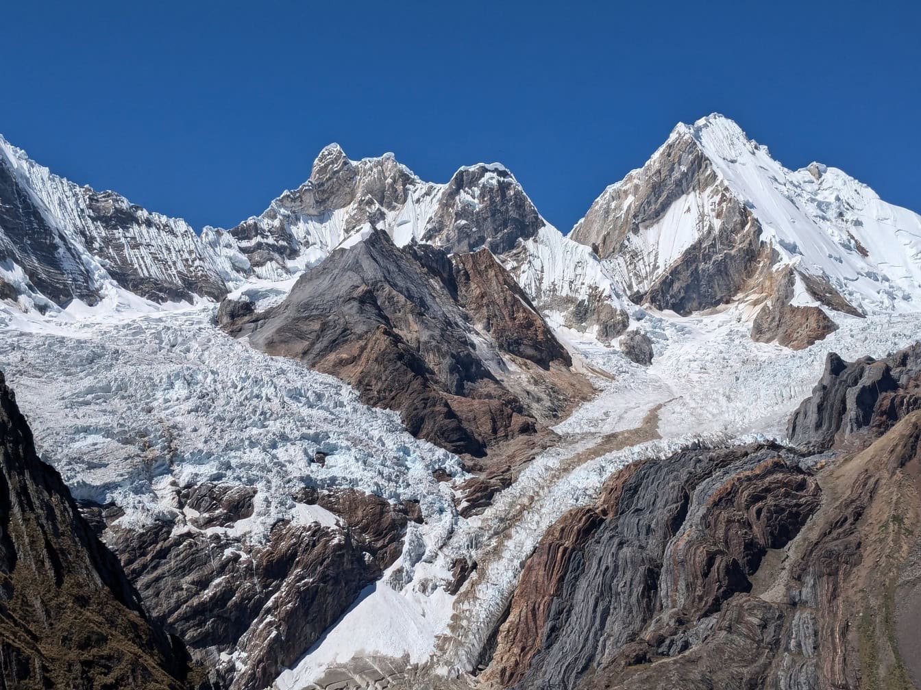 Ghiacciaio ghiacciato alle cime delle montagne di una catena montuosa della Cordigliera Huayhuash nelle Ande del Perù con un cielo blu come sfondo