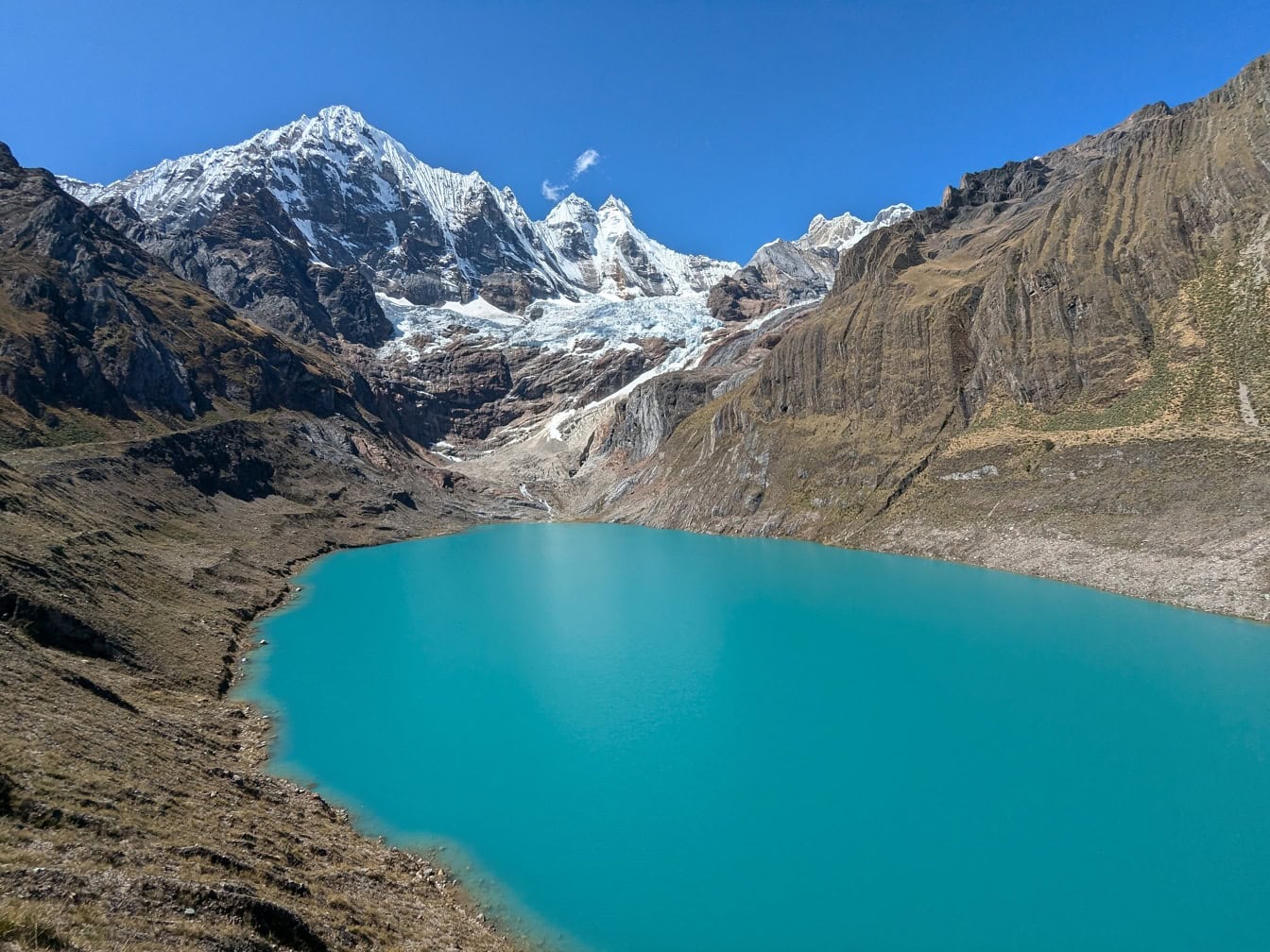 En naturskøn udsigt over turkis Llanguanco sø i naturpark ved Cordillera Huayhuash bjergkæde i Andesbjergene i Peru