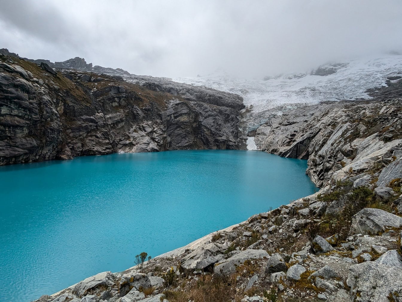 Turkisblå farge på innsjøen 513 ved foten av Nevado Hualcan-fjellet i Huascaran nasjonalpark i Peru