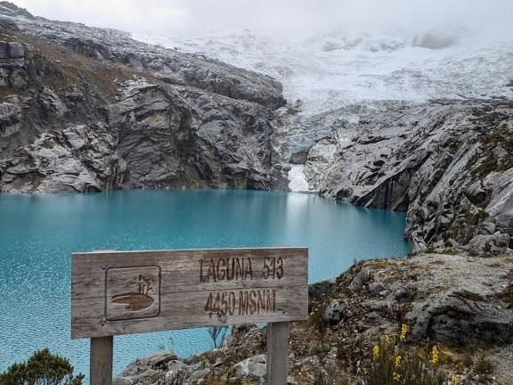 Знак на берегу озера 513 у подножия Невадо-Уалькана в национальном парке Уаскаран на высоте 4450 метров над уровнем моря
