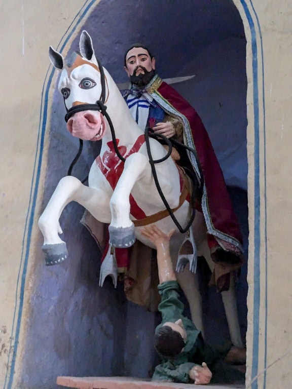 Sadrová socha jazdca na koni, ktorý skáče cez iného muža pod koňom