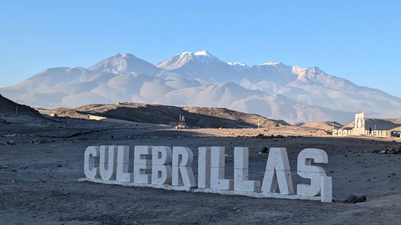 Panneau blanc avec une inscription des Culebrillas dans le désert d’Arequipa au Pérou avec des montagnes en arrière-plan