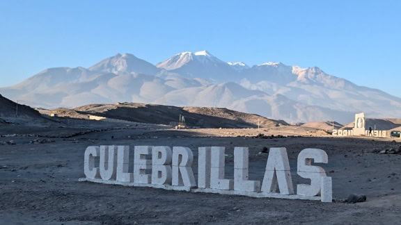 Hvidt skilt med inskription af Culebrillas i ørkenen i Arequipa i Peru med bjerge i baggrunden
