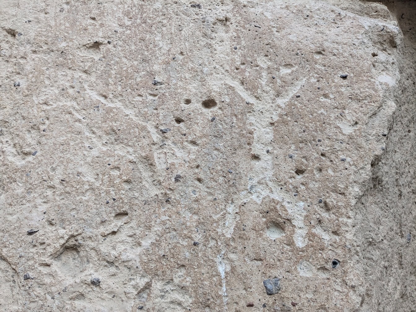 Kiveen kaiverrettu kalliopiirros, joka kuvaa kivikauden henkilöä, jolla on ojennetut kädet ja jalat