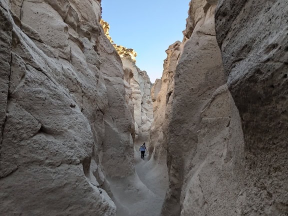 Person walking through a narrow canyon in Peru
