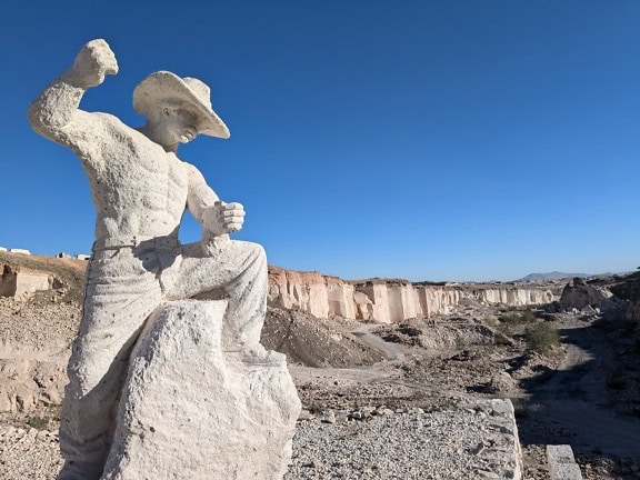 Statue of a cowboy with hat in a desert at the Sillar route near Culebrillas canyon in Arequipa in Peru