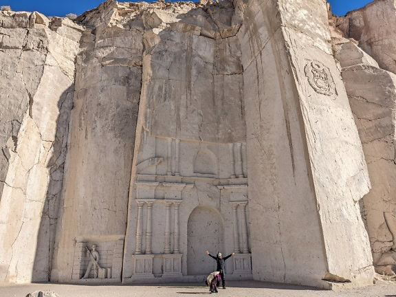 Чоловік стоїть перед великою різьбленою скелею в Арекіпі вздовж маршруту Сіллар біля каньйону Кулебрільяс