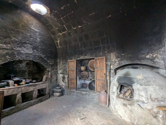 Средневековая кухня с каменной печью и полками с терракотовыми горшками в монастыре Санта-Каталина в Арекипе в Перу