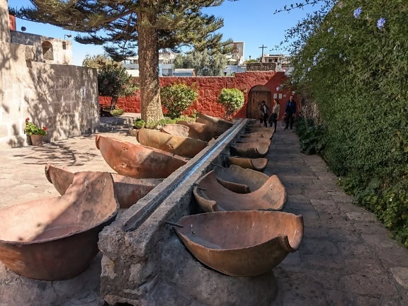 Air mancur dengan mangkuk besar di atas balok batu di taman Biara Santa Catalina di Arequipa, Peru