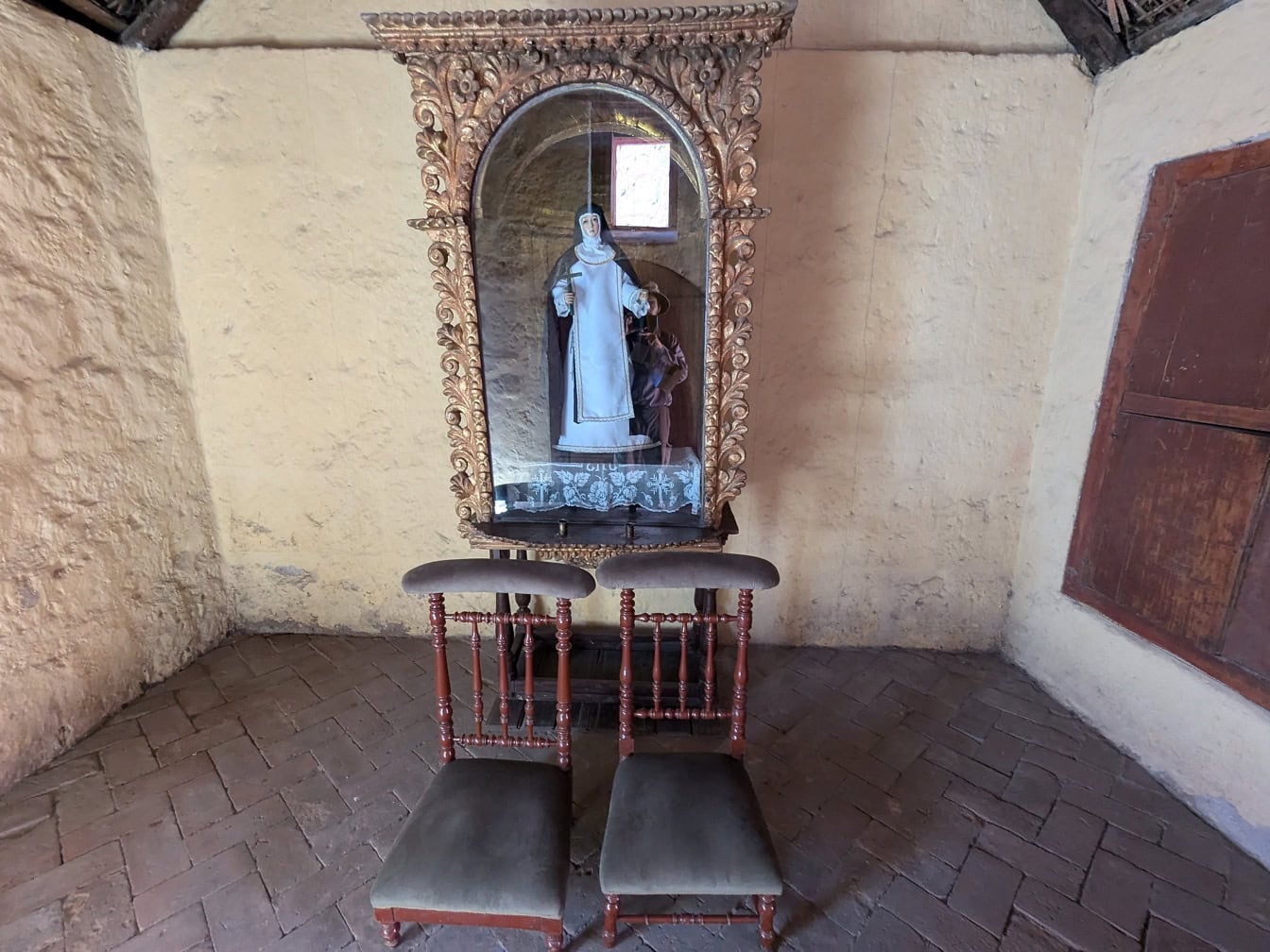 Statue av en nonne i et rom med stoler i katolsk kloster i Peru