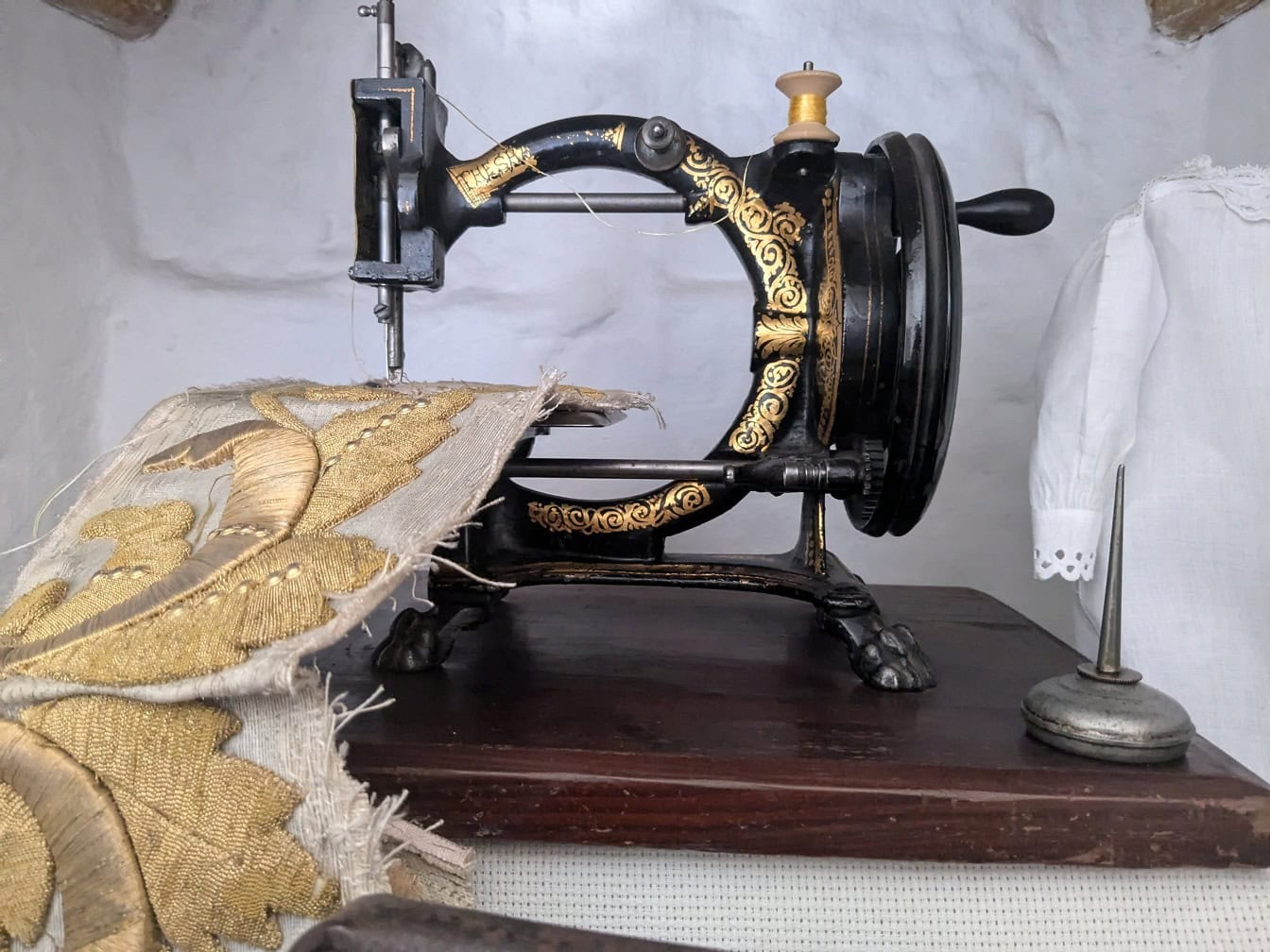 Antik öntöttvas kézi forgattyús varrógép az asztalon