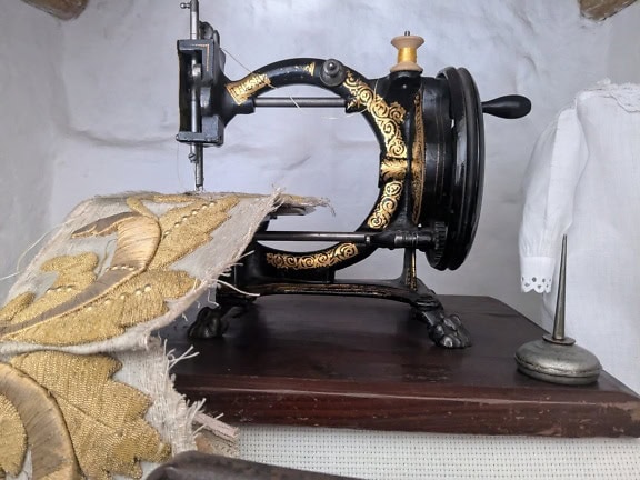 Antica macchina da cucire a manovella in ghisa su un tavolo