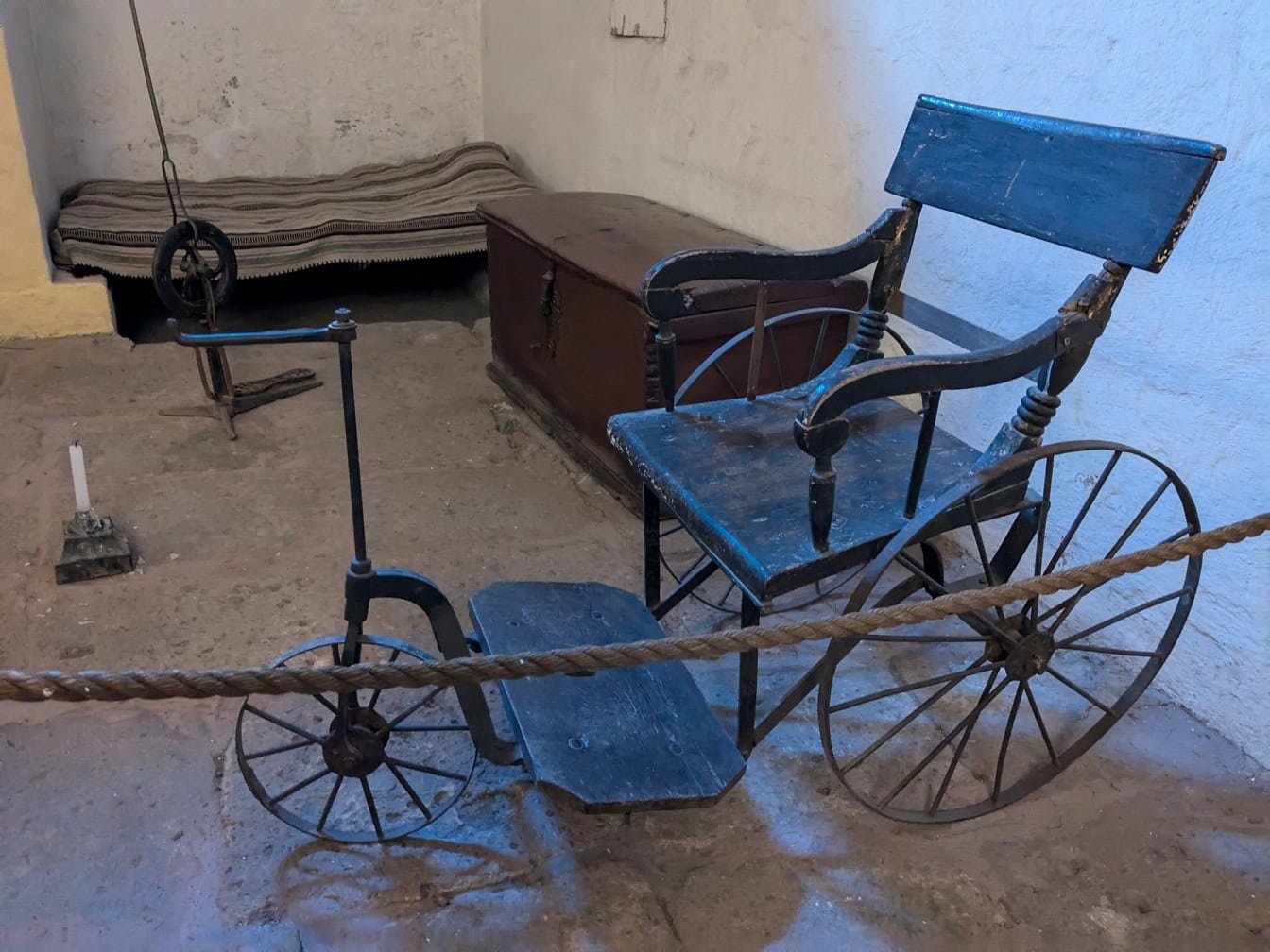Cadeira de rodas feito a mão medieval velha do triciclo no museu