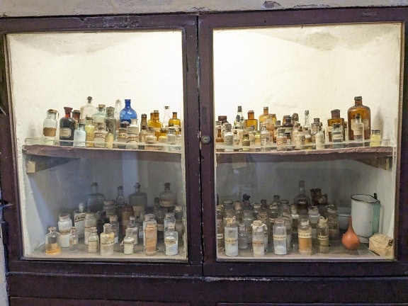 Lahvičky s léky a chemikáliemi v regálech muzeí