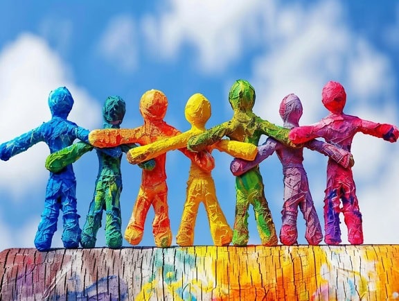 Färgglada pappersfigurer som håller händer, en illustration av samhörighet, tolerans och jämlikhet mellan olika etniska grupper av människor
