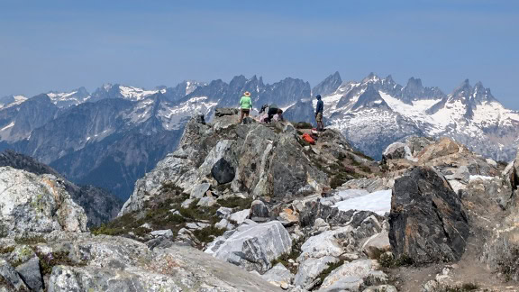 Horolezci stojící na skalnatém vrcholu hory v Peru