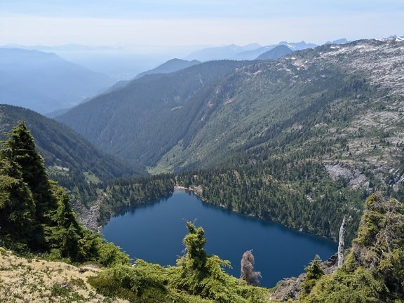 Beira bonita do lago de Thornton com montanhas no fundo no parque nacional North Cascades em Washington