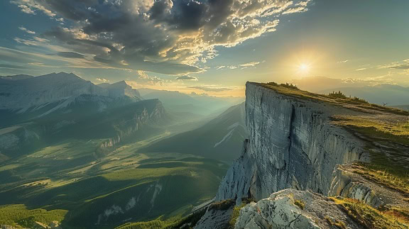 View of a valley and mountains from a cliff at sunrise