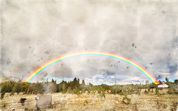 Abstracte artistieke fotomontage van een aquarel van een regenboog over een veld