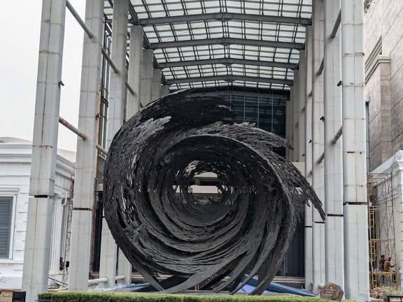 Groot zwart beeldhouwwerk in een stijl van draaikolk in het nationale museum van Indonesië